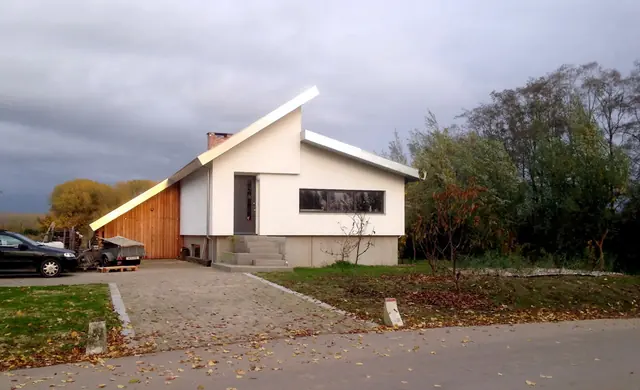 Moderne nieuwbouwwoning met wit stucwerk en houten gevelpaneel in Alem