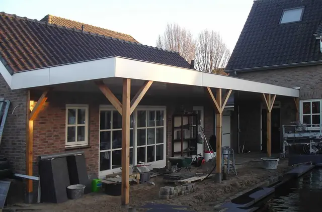 De carport aan de rechterzijde van de woning tijdens de bouw