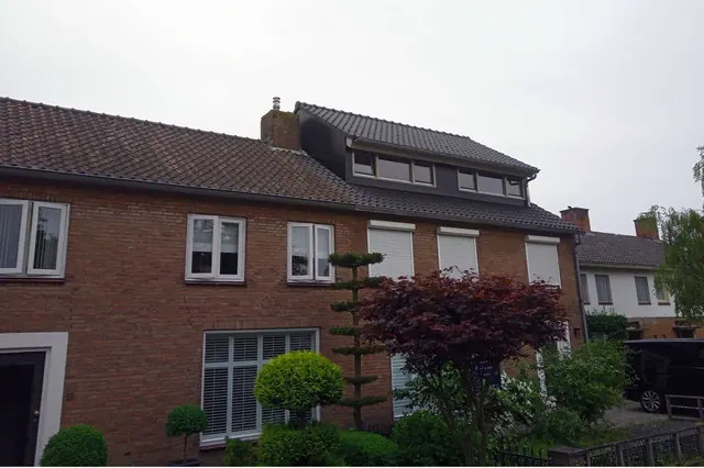 Verbouwde woning van rode baksteen met een gesnoeide tuin in Haarsteeg