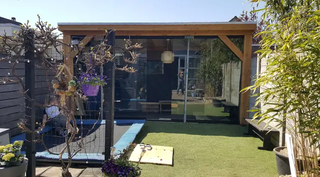 Overkapping van Douglashout met glazen wanden bij een tuin in Den Bosch