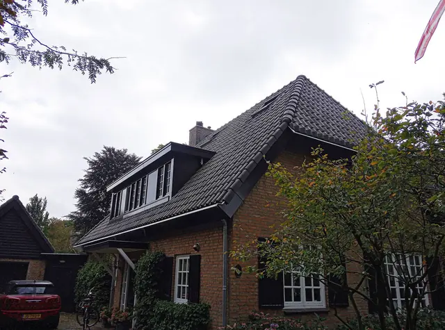 Gerenoveerd dak met dakkapellen op een woning van bruine baksteen in Vught